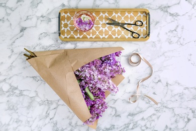 Flat lay composition with beautiful blossoming lilac on light background. Spring flowers