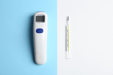 Photo of Non-contact infrared and mercury thermometers on color background, flat lay