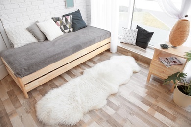 Photo of Modern living room interior with wooden furniture and furry carpet