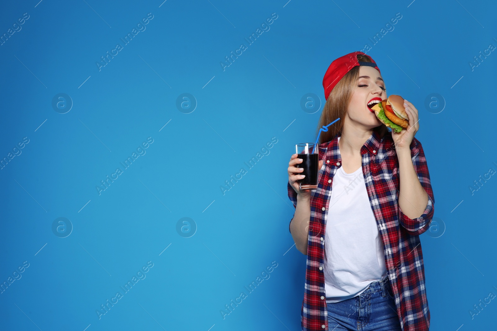 Photo of Pretty woman with tasty burger and cola on color background. Space for text