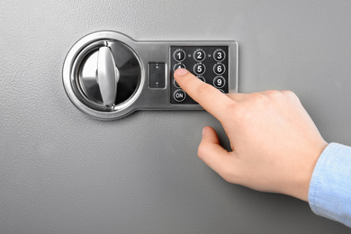 Man opening steel safe with electronic combination lock, closeup