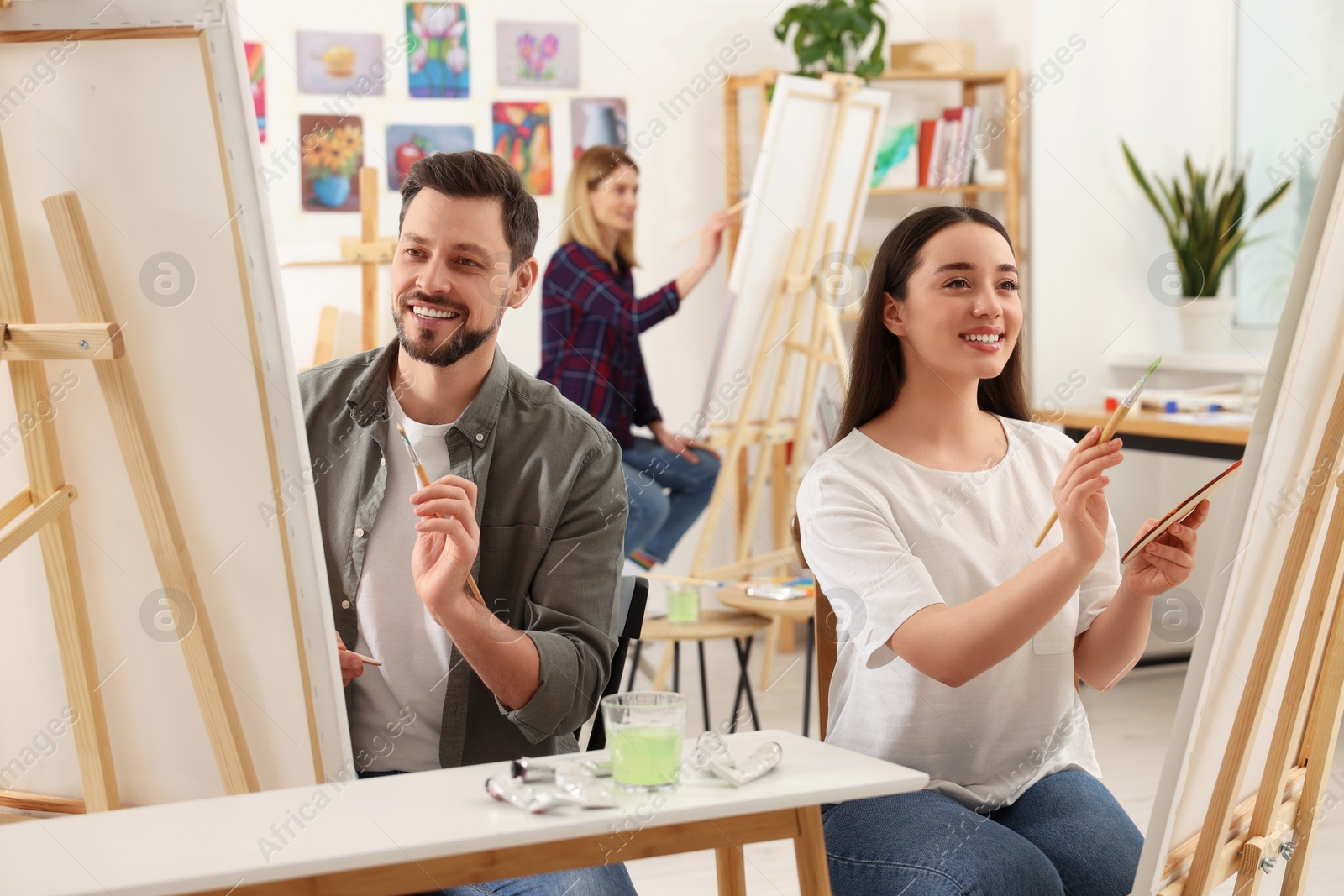 Photo of Group of students attending painting class in studio. Creative hobby