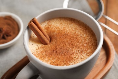 Photo of Delicious eggnog with anise and cinnamon on wooden table, closeup