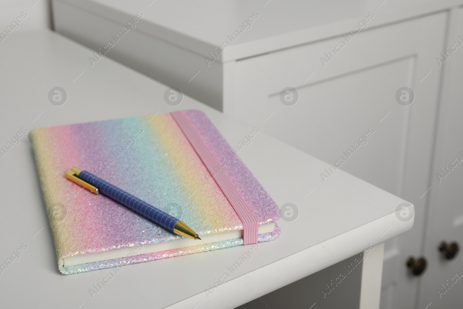 Photo of Bright planner and pen on white table indoors, space for text