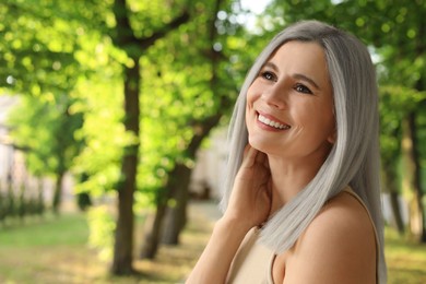 Image of Portrait of smiling woman with ash hair color outdoors. Space for text