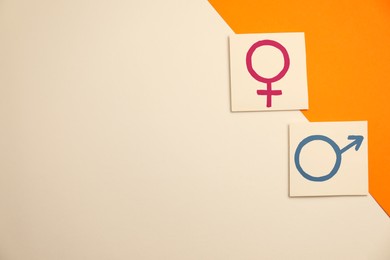 Photo of Gender equality. Cards with male and female symbols on color background, flat lay. Space for text
