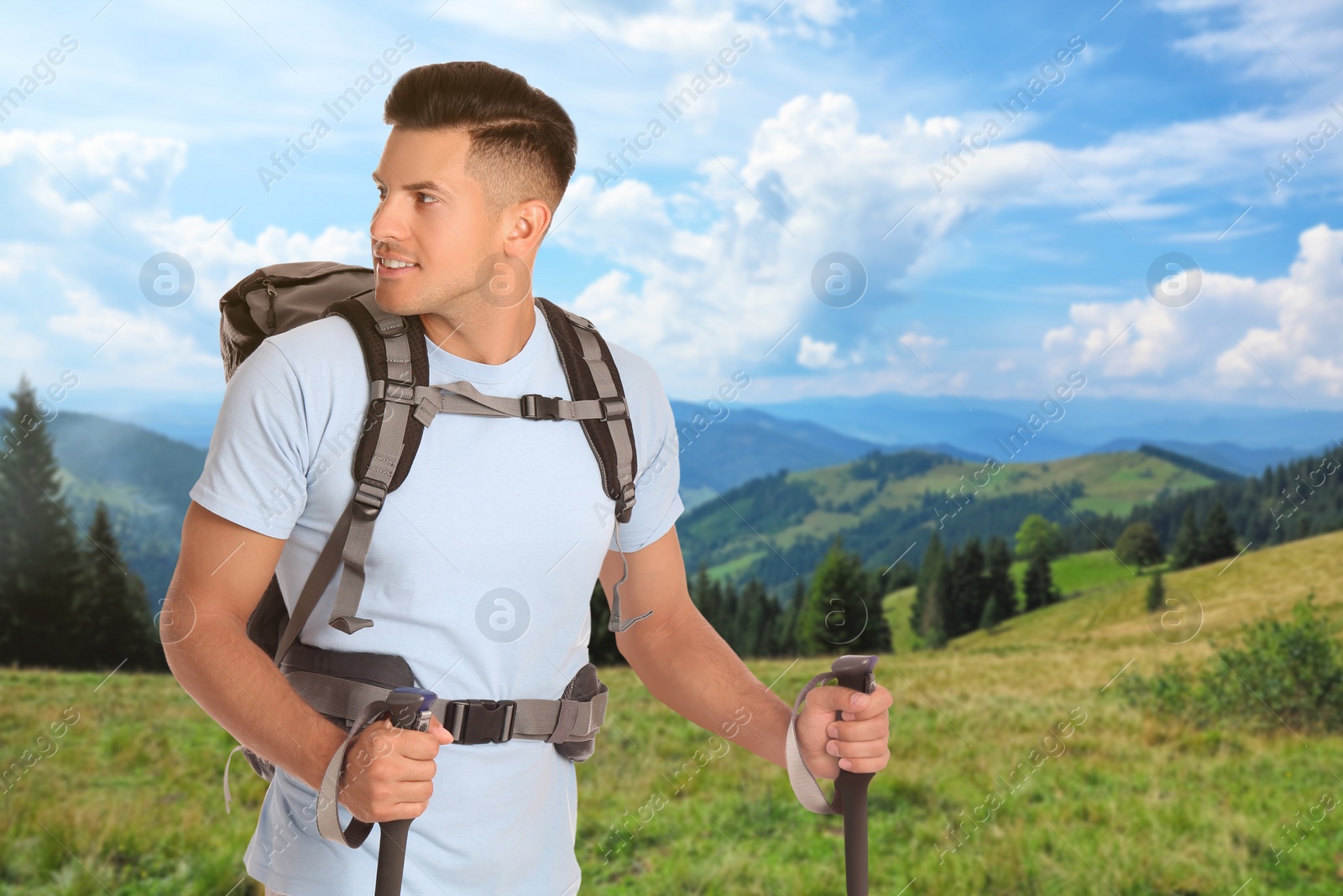 Image of Man with backpack and trekking poles in mountains on sunny day