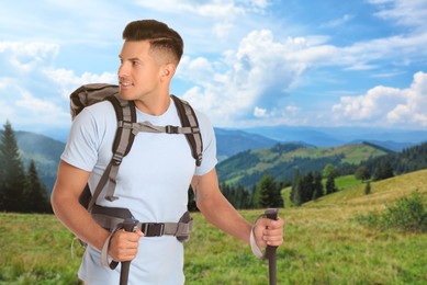 Image of Man with backpack and trekking poles in mountains on sunny day