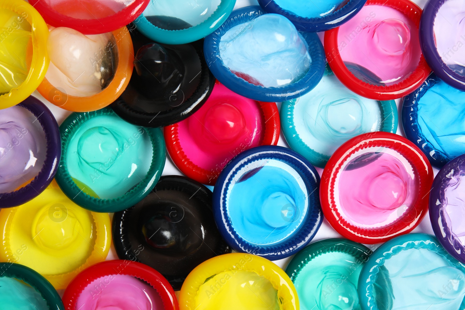 Photo of Unpacked colorful condoms as background, top view. Safe sex