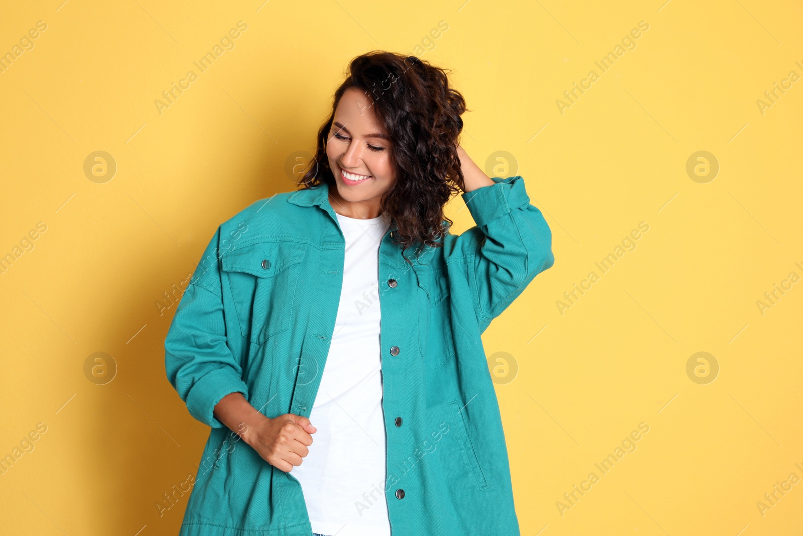 Photo of Happy young woman in casual outfit on yellow background