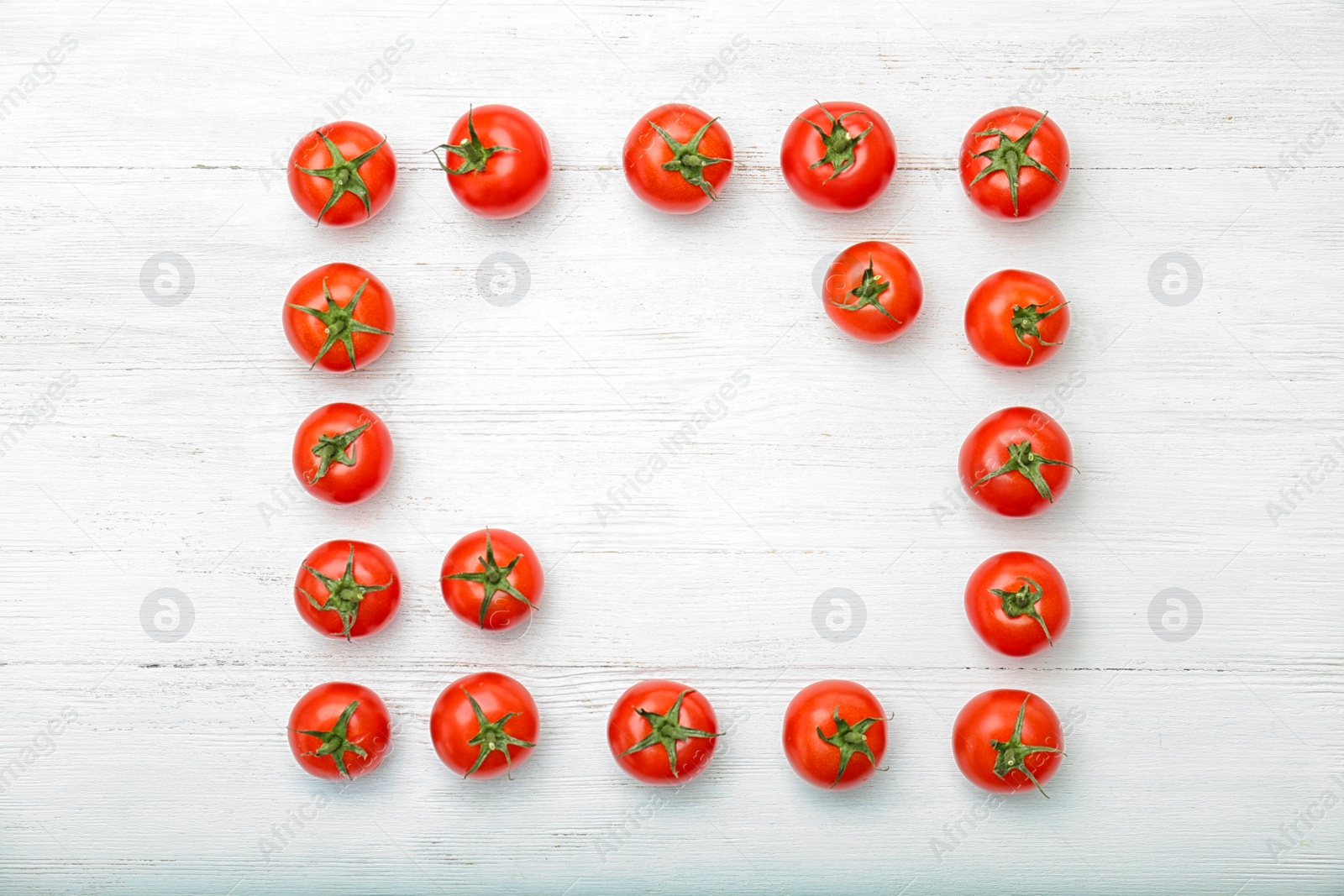 Photo of Frame made of ripe tomatoes on wooden background