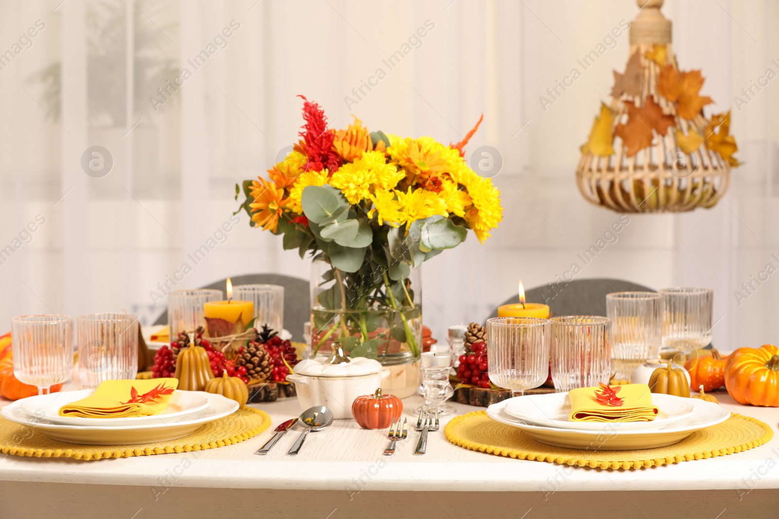 Photo of Autumn table setting with floral decor and pumpkins indoors