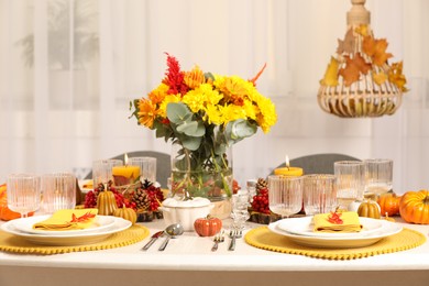 Photo of Autumn table setting with floral decor and pumpkins indoors