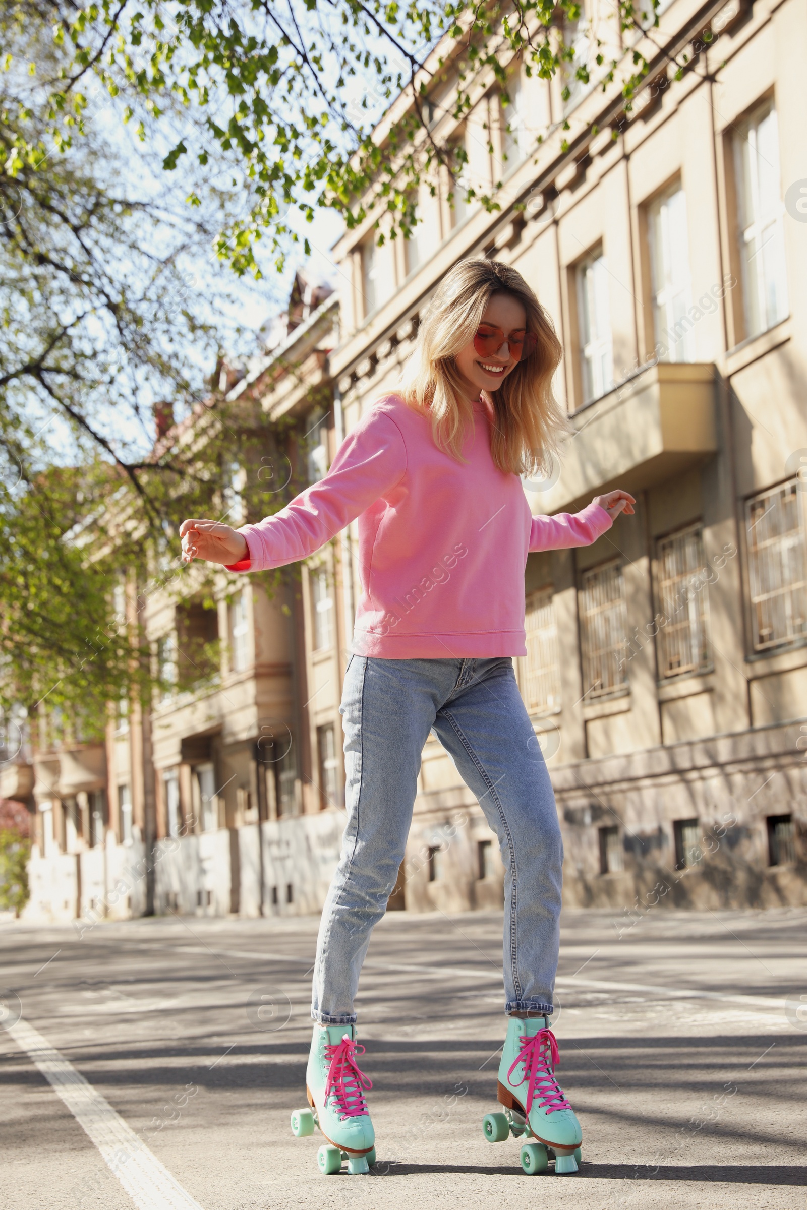 Photo of Beautiful young woman roller skating outdoors on sunny day