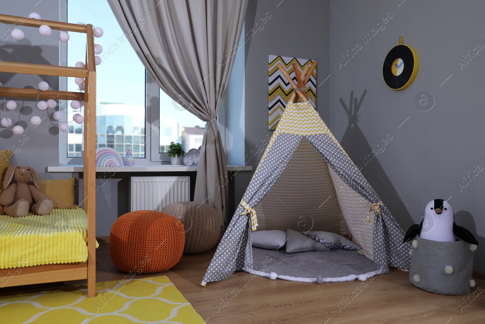 Photo of Stylish child room interior with comfortable house bed and play tent