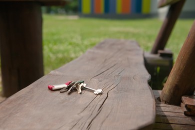 Photo of Keys forgotten on wooden bench outdoors. Lost and found