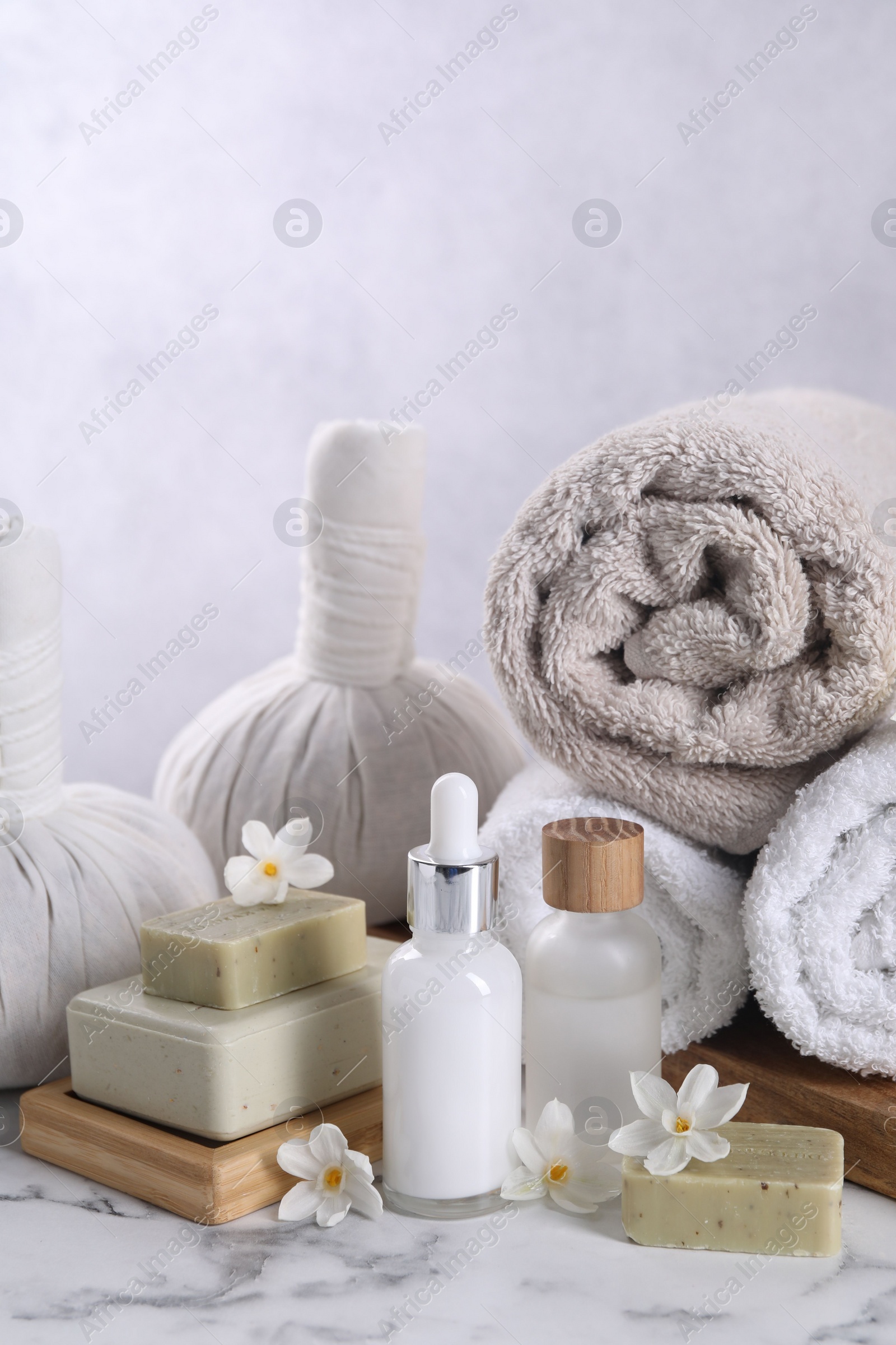 Photo of Composition with spa supplies and flowers on white marble table
