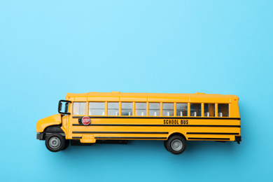 Photo of Yellow school bus on light blue background, top view with space for text. Transport service
