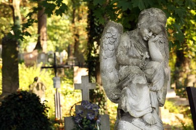 Photo of Beautiful statueangel at cemetery on sunny day, space for text. Funeral ceremony