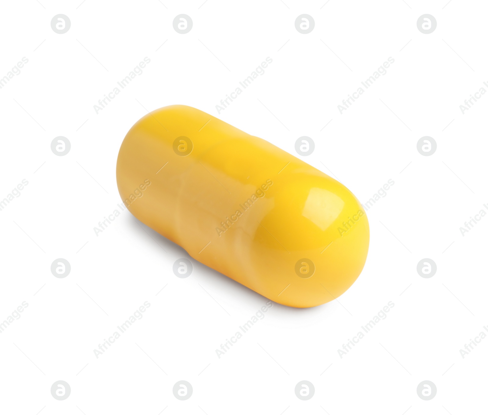 Photo of One yellow pill on white background. Medicinal treatment