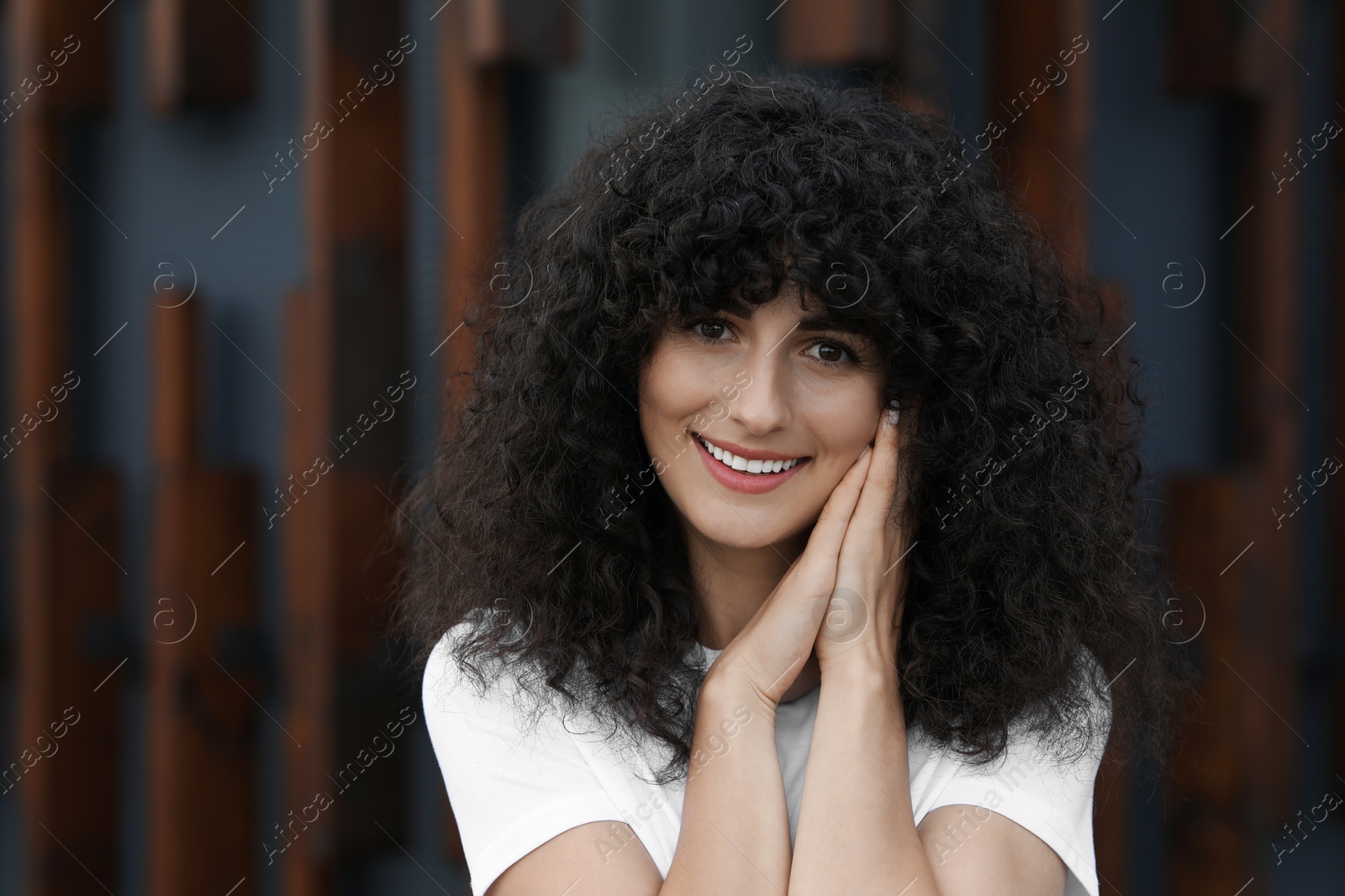 Photo of Portrait of beautiful woman posing near building. Attractive lady smiling and looking into camera. Space for text