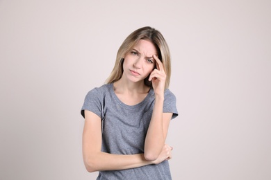 Photo of Portrait of stressed young woman on light background