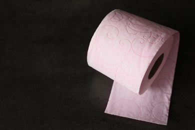 Soft toilet paper roll on black background. Space for text