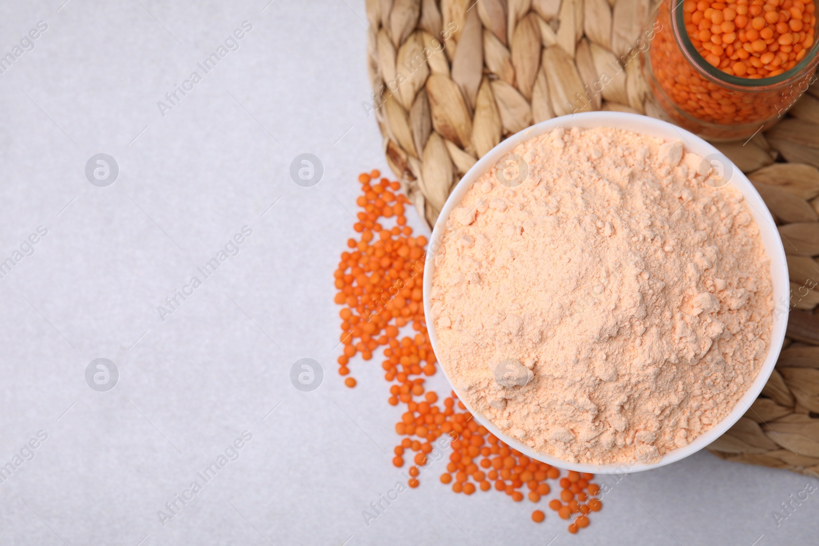 Photo of Lentil flour and jar seeds on white table, flat lay. Space for text