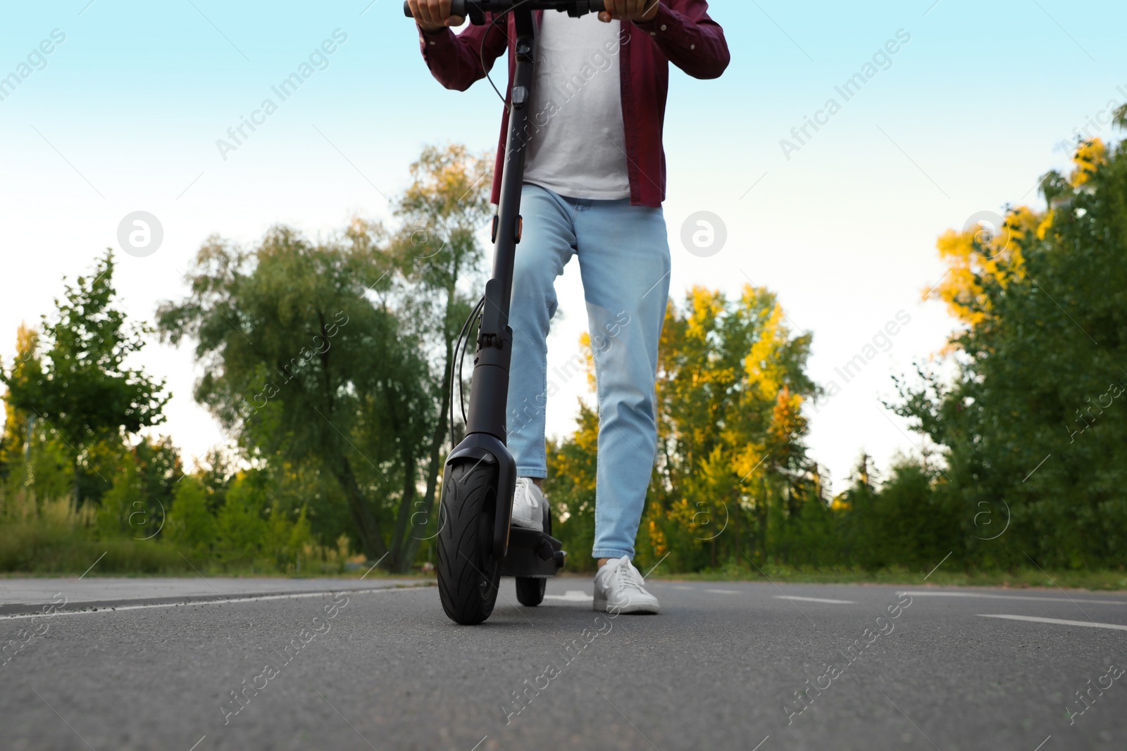 Photo of Man with modern electric kick scooter in park, closeup