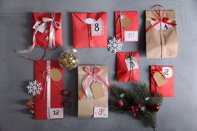 Set of different gifts and Christmas decor on grey stone table, flat lay. Advent calendar