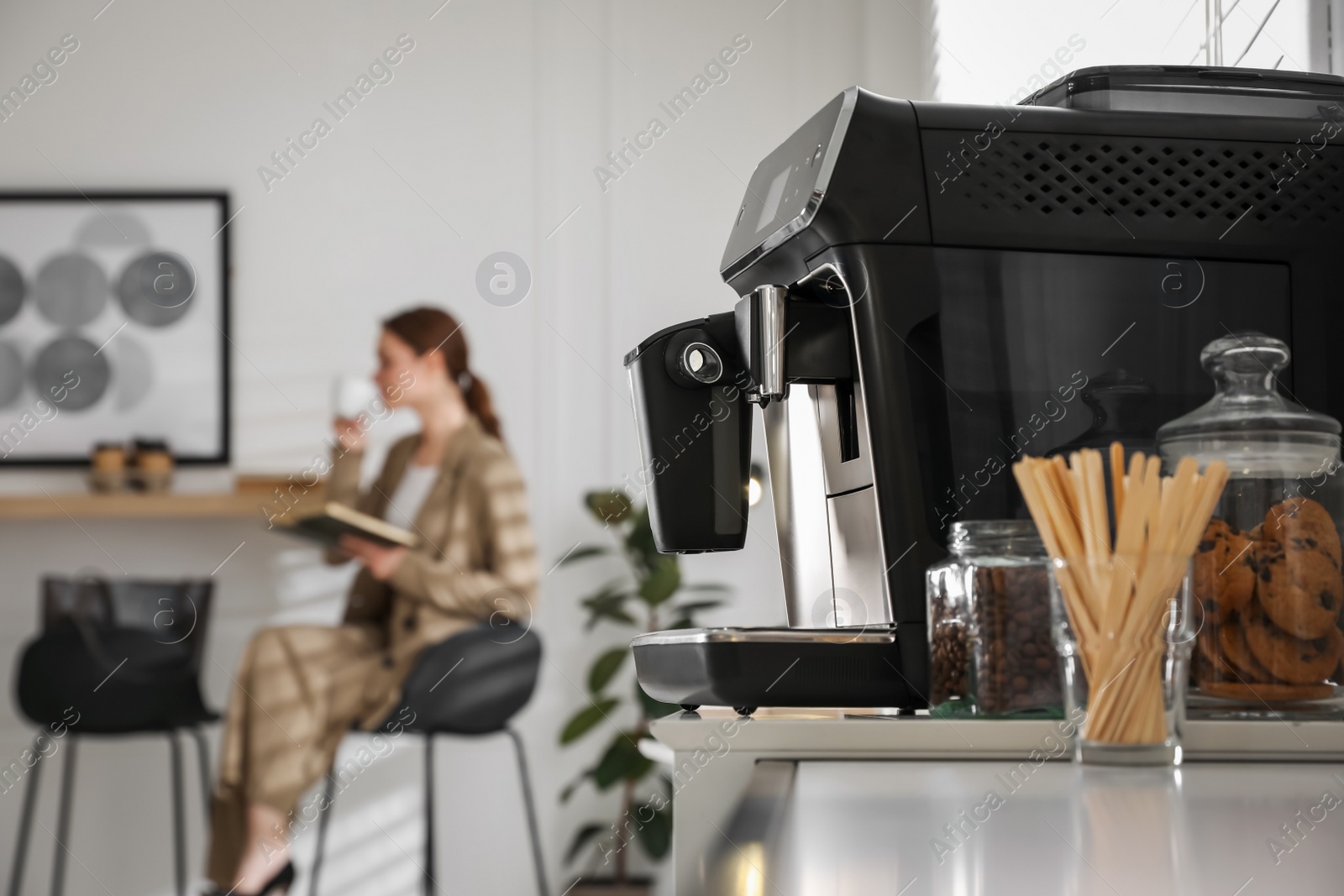 Photo of Modern electric coffee machine on table in office. Space for text