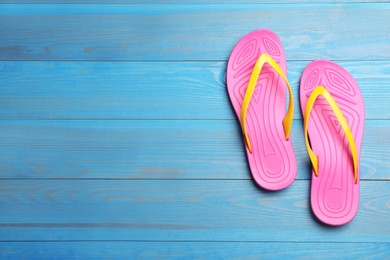 Photo of Stylish beach flip flops on blue wooden background, flat lay. Space for text