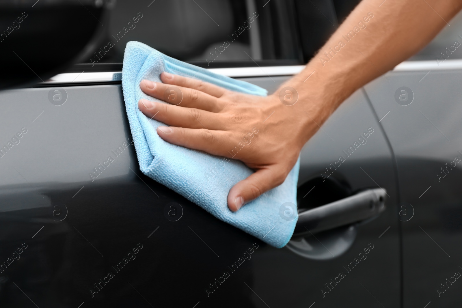 Photo of Man washing car door with rag, closeup