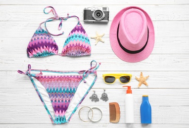 Photo of Flat lay composition with beach accessories on white wooden background