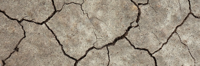 Dry cracked ground as background, top view. Banner design