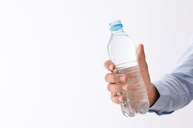 Photo of Man holding bottle of pure water on white background, closeup. Space for text