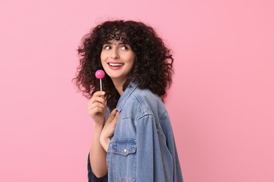 Photo of Beautiful woman with lollipop on pink background