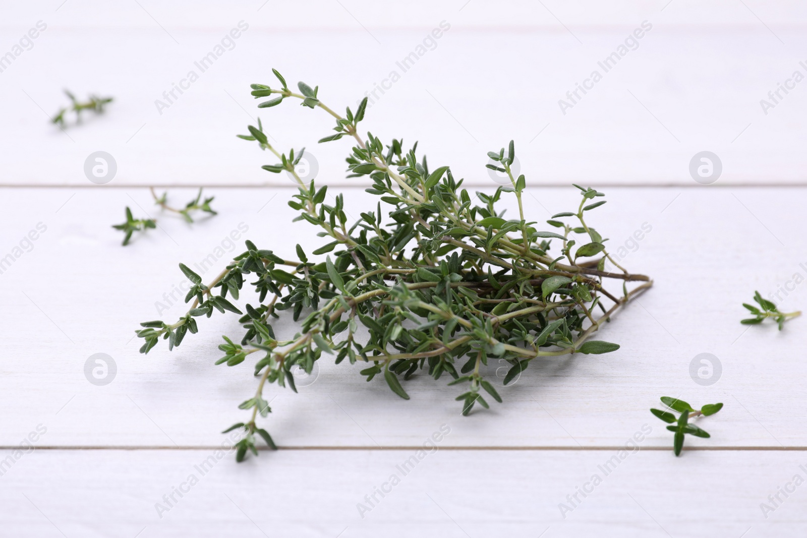 Photo of Bunch of fresh thyme on white wooden table