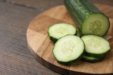 Photo of Fresh cut cucumber on wooden table, closeup. Space for text