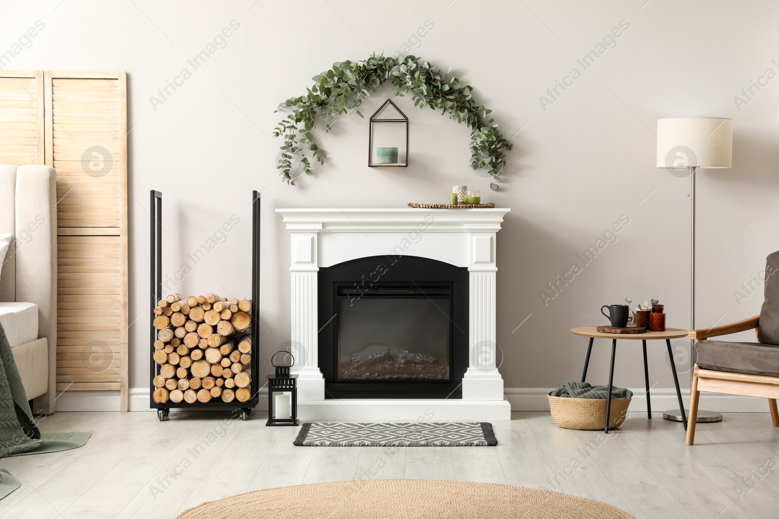 Photo of Stylish room decorated with beautiful eucalyptus garland above fireplace