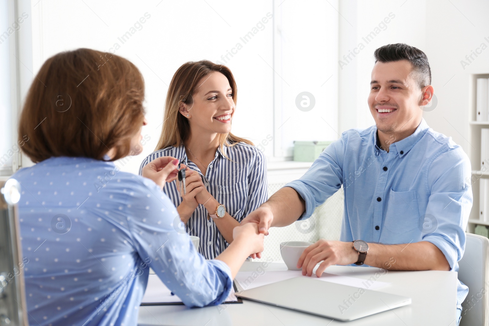 Photo of Real estate agent consulting young couple in office