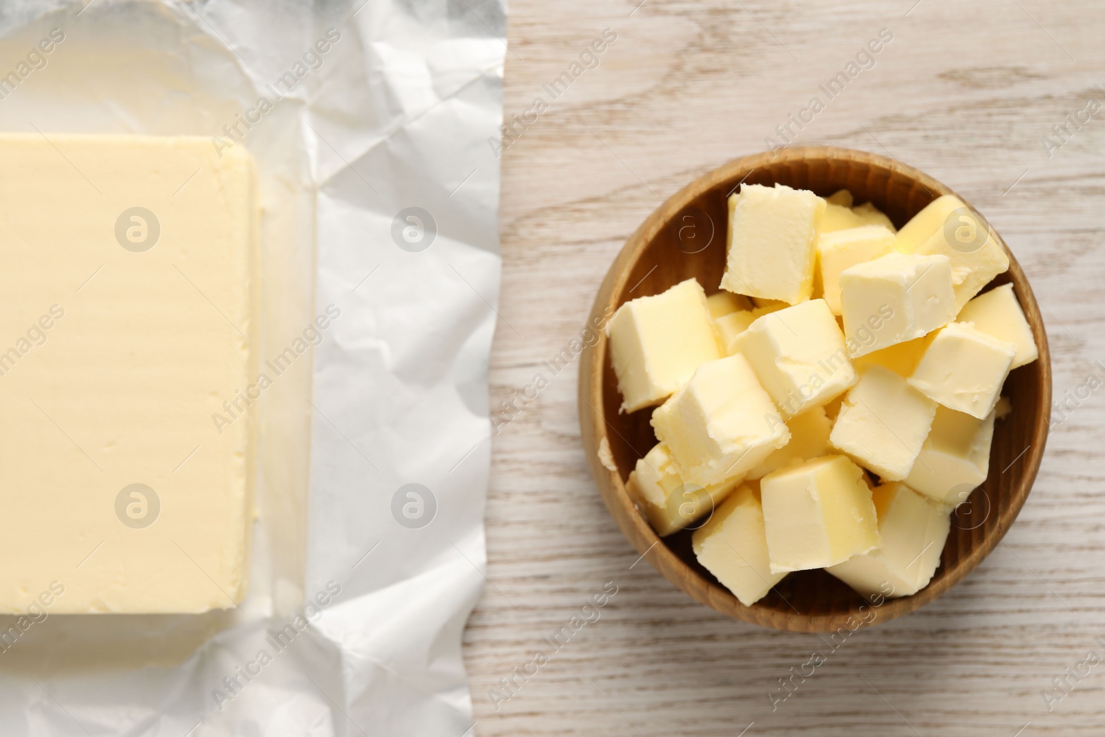 Photo of Tasty butter on light wooden table, flat lay