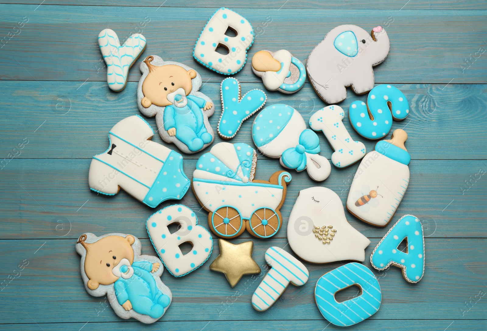 Photo of Set of baby shower cookies on turquoise wooden table, flat lay