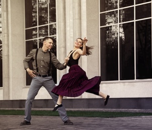 Photo of Beautiful young couple practicing dance moves on city street
