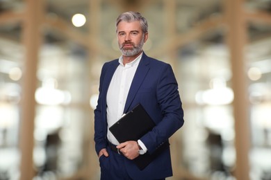 Successful lawyer with clipboard on blurred background