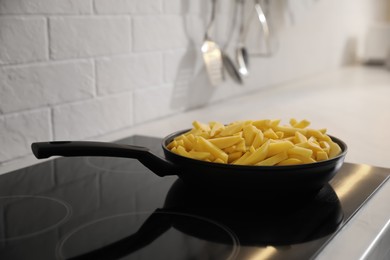 Photo of Frying pan with cut raw potatoes on cooktop