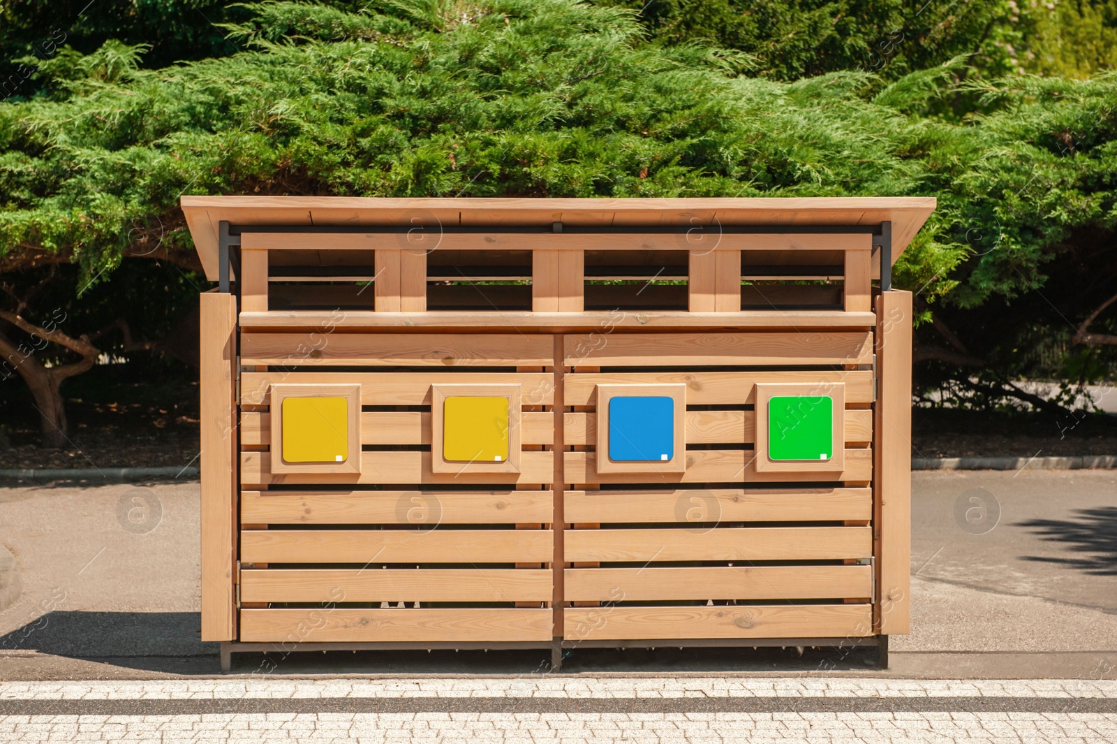 Photo of Wooden recycling bins for waste sorting outdoors