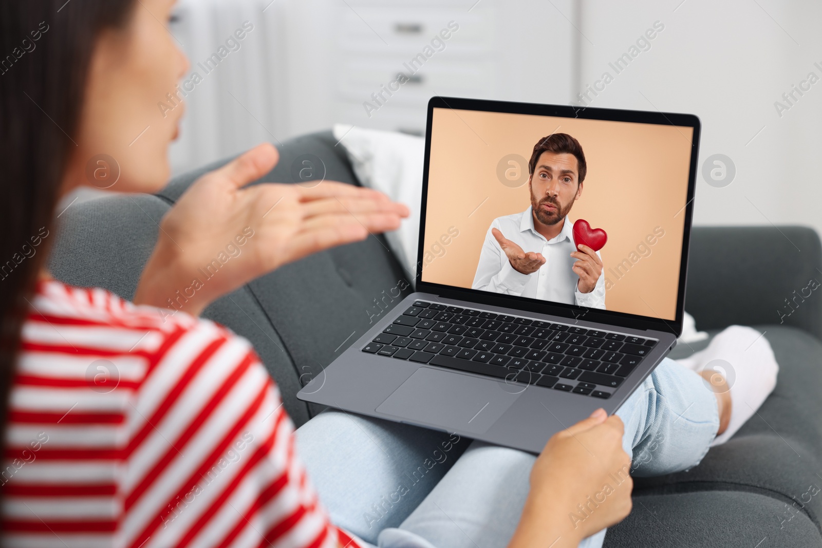 Image of Long distance love. Woman having video chat with her boyfriend via laptop at home, closeup