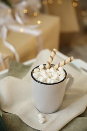 Photo of Cup of cocoa with wafer tubes on table indoors. Christmas celebration