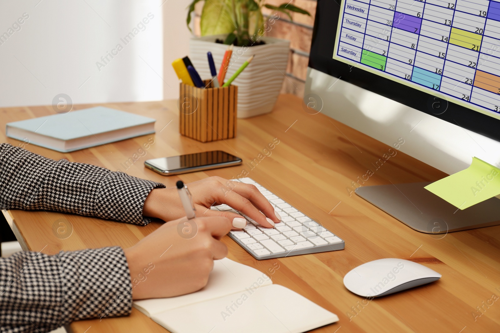 Photo of Woman using calendar app on computer in office, closeup